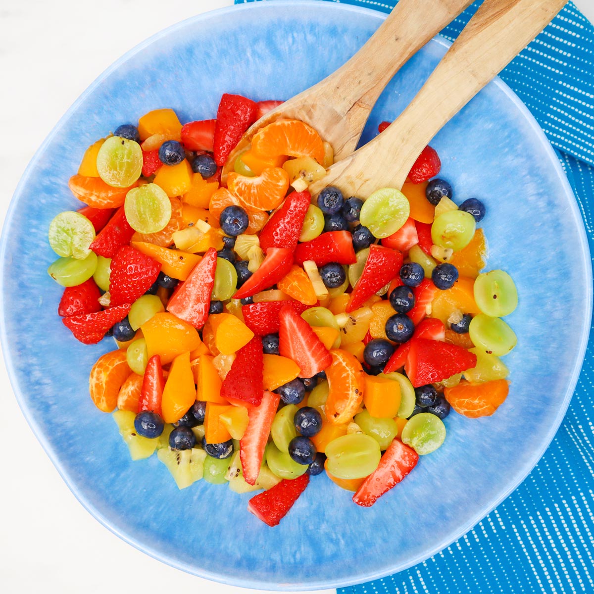 Summer Fruit Salad A colorful summer fruit salad with strawberries, blueberries, grapes, and mandarin oranges in a blue bowl.