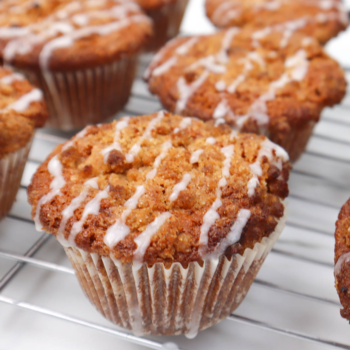Coffee Cake Breakfast Muffins Freshly baked coffee cake breakfast muffins with a drizzle of icing on top.
