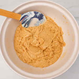 Bowl of coffee cake muffin batter with a spatula.