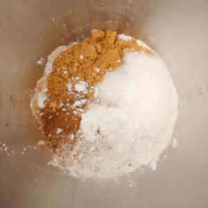 A mixture of brown sugar, white sugar, and flour in a mixing bowl.