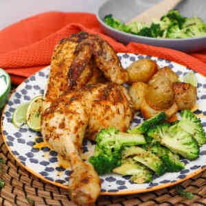Um prato de frango aberto ao estilo mexicano, servido com batatas assadas e brócolis.