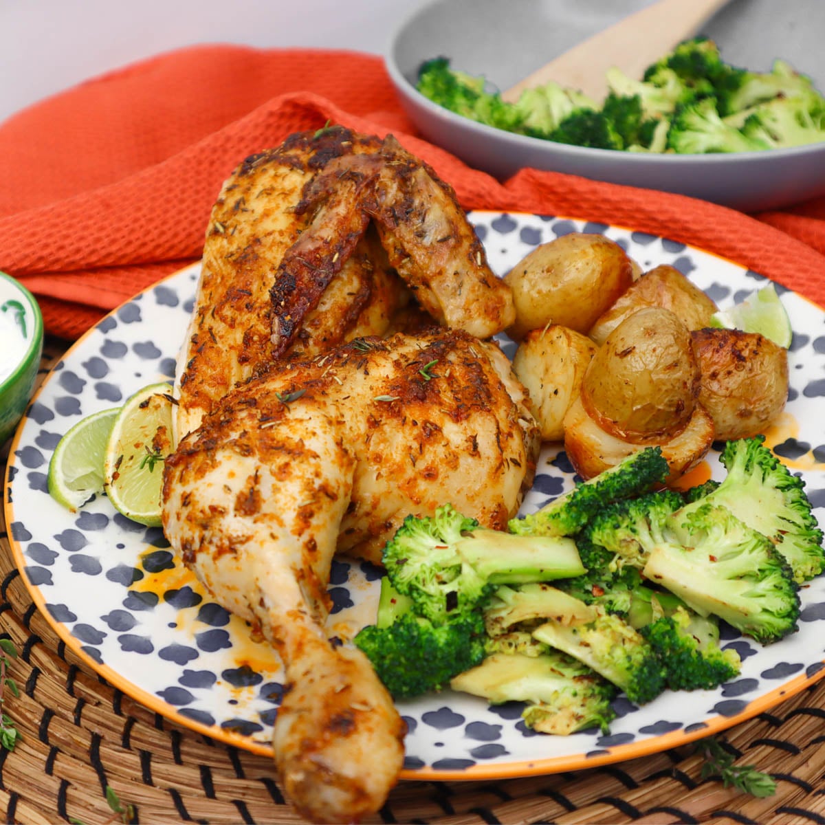 Frango aberto ao estilo mexicano Um prato de frango aberto ao estilo mexicano, servido com batatas assadas e brócolis.