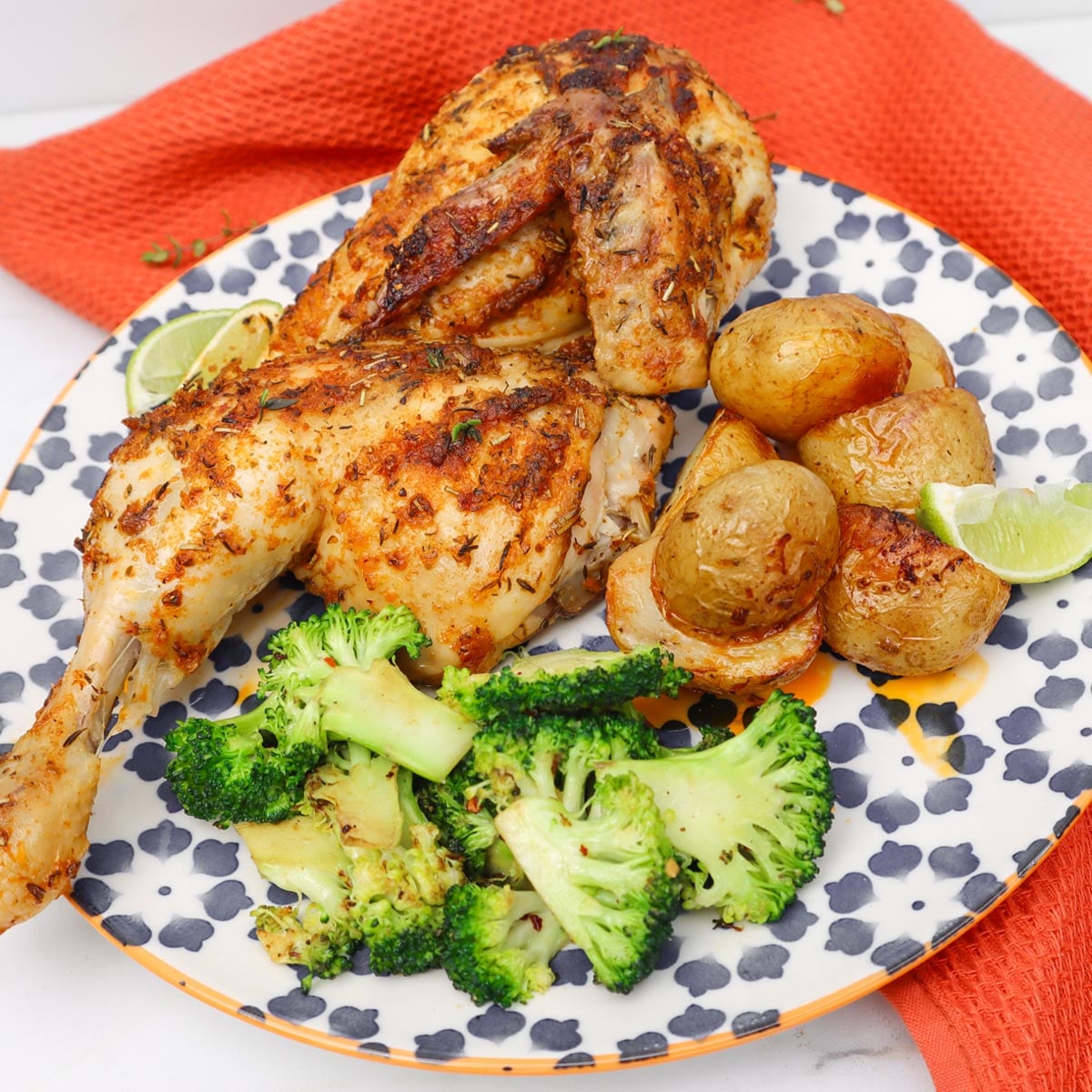 Frango aberto ao estilo mexicano Um prato de frango aberto ao estilo mexicano, servido com batatas assadas e brócolis.