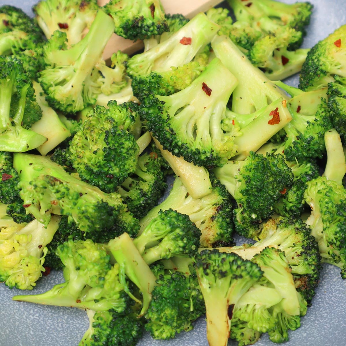 Brócoli salteado Brócoli salteado con un vibrante color verde y un toque de condimento rojo.