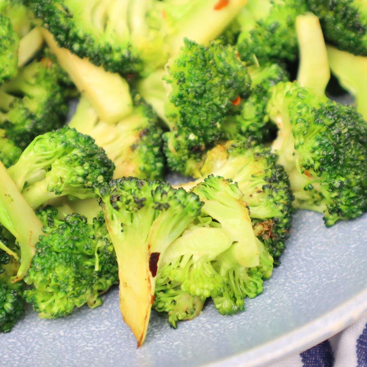 Brócoli salteado Primer plano de trozos de brócoli salteados en un plato.