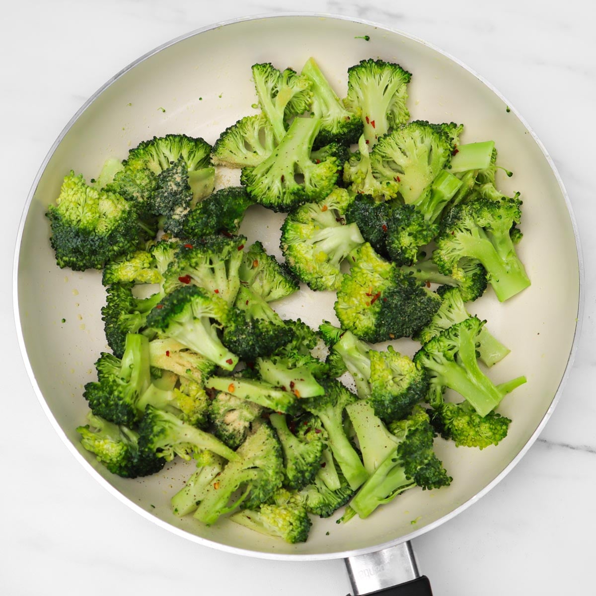 Brócoli salteado Una sartén llena de floretes de brócoli salteados, sazonados y de un verde vibrante.