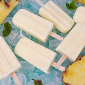 Refreshing pineapple popsicles on ice with mint leaves.
