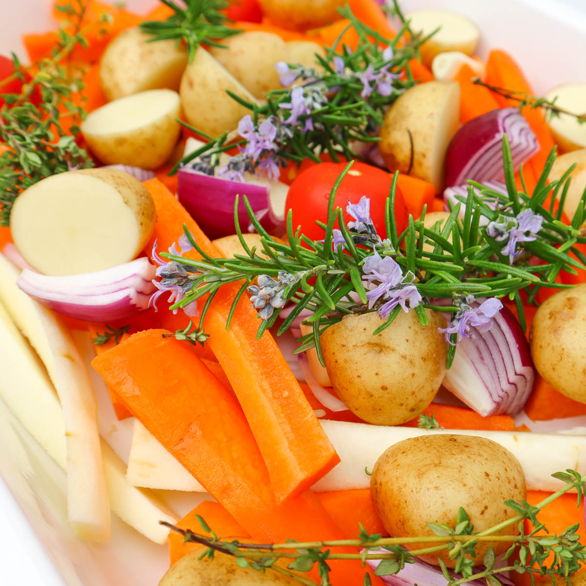 Roasted Vegetable Tray Bake A colorful assortment of roasted vegetables including carrots, potatoes, and herbs.