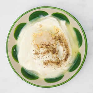 A bowl of sour cream dip topped with spices, ready for dipping.