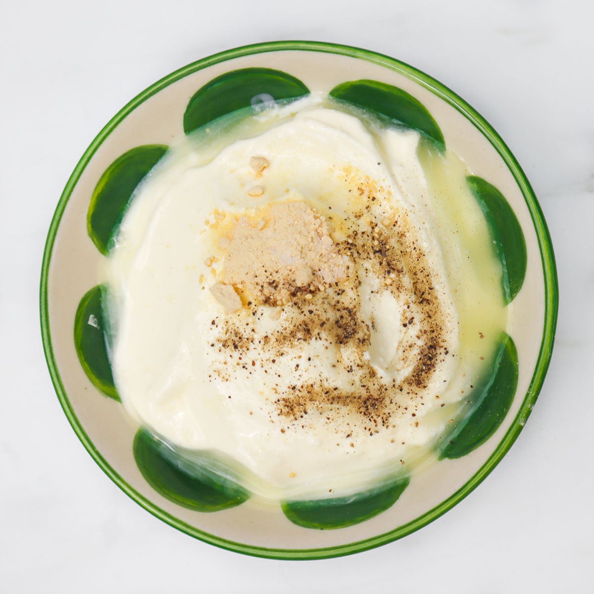 Sour Cream and Chive Dip A bowl of sour cream dip topped with spices, ready for dipping.