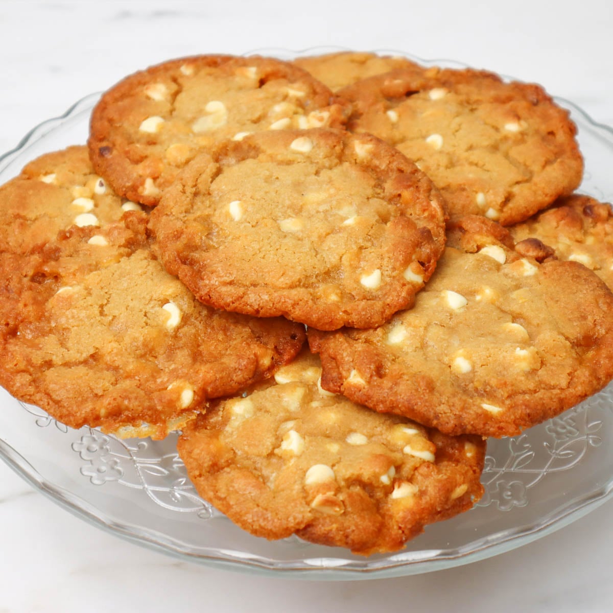 Biscoitos de chocolate branco com gotas de chocolate e favo de mel Um prato de biscoitos recém-assados com gotas de chocolate branco e favo de mel.