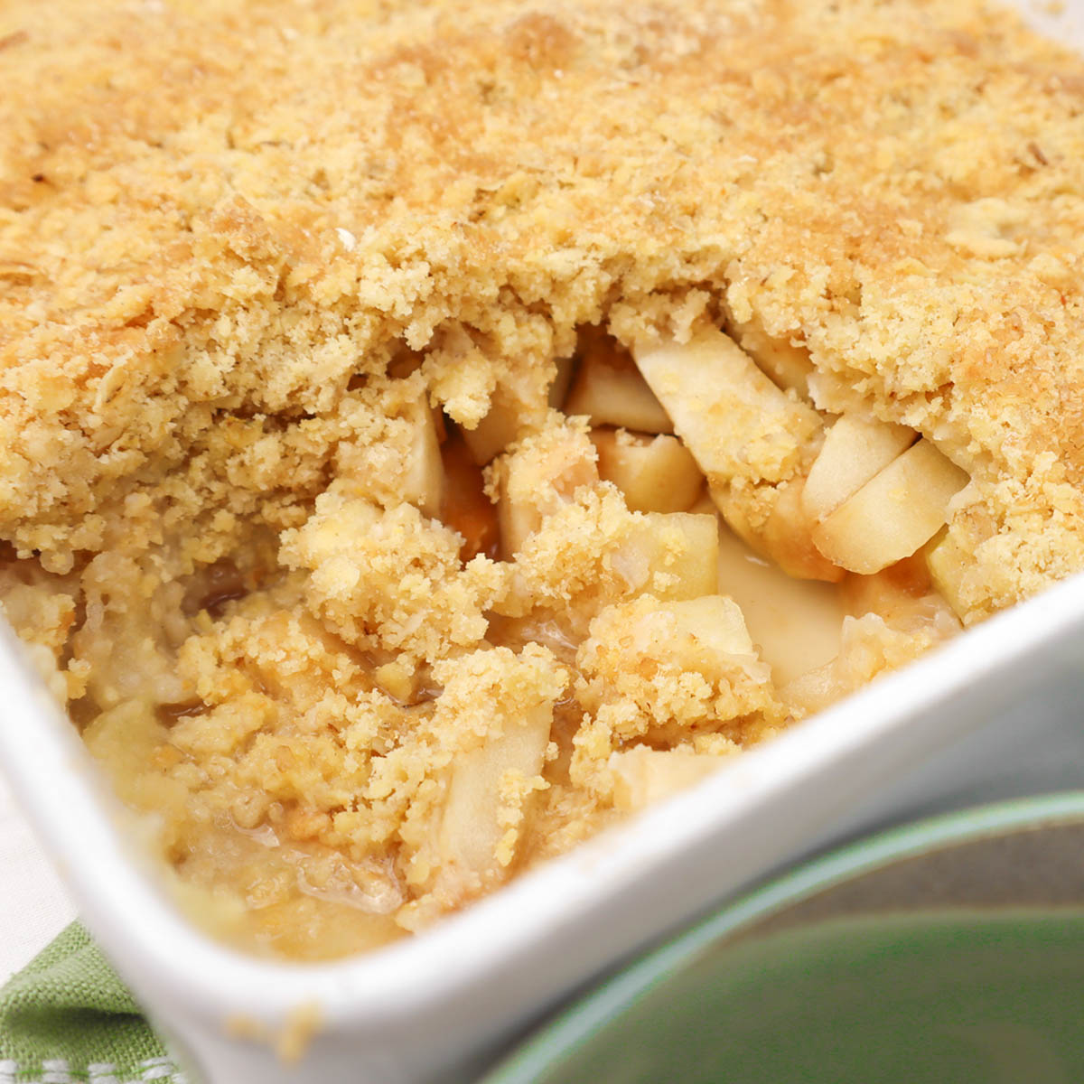 Apple Crumble A close-up of a baked apple crumble with a golden, crumbly topping and visible apple slices inside.