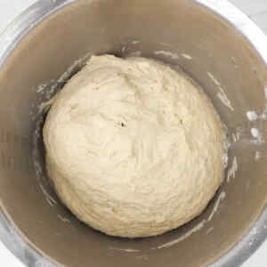 A bowl of dough rising for homemade burger buns.