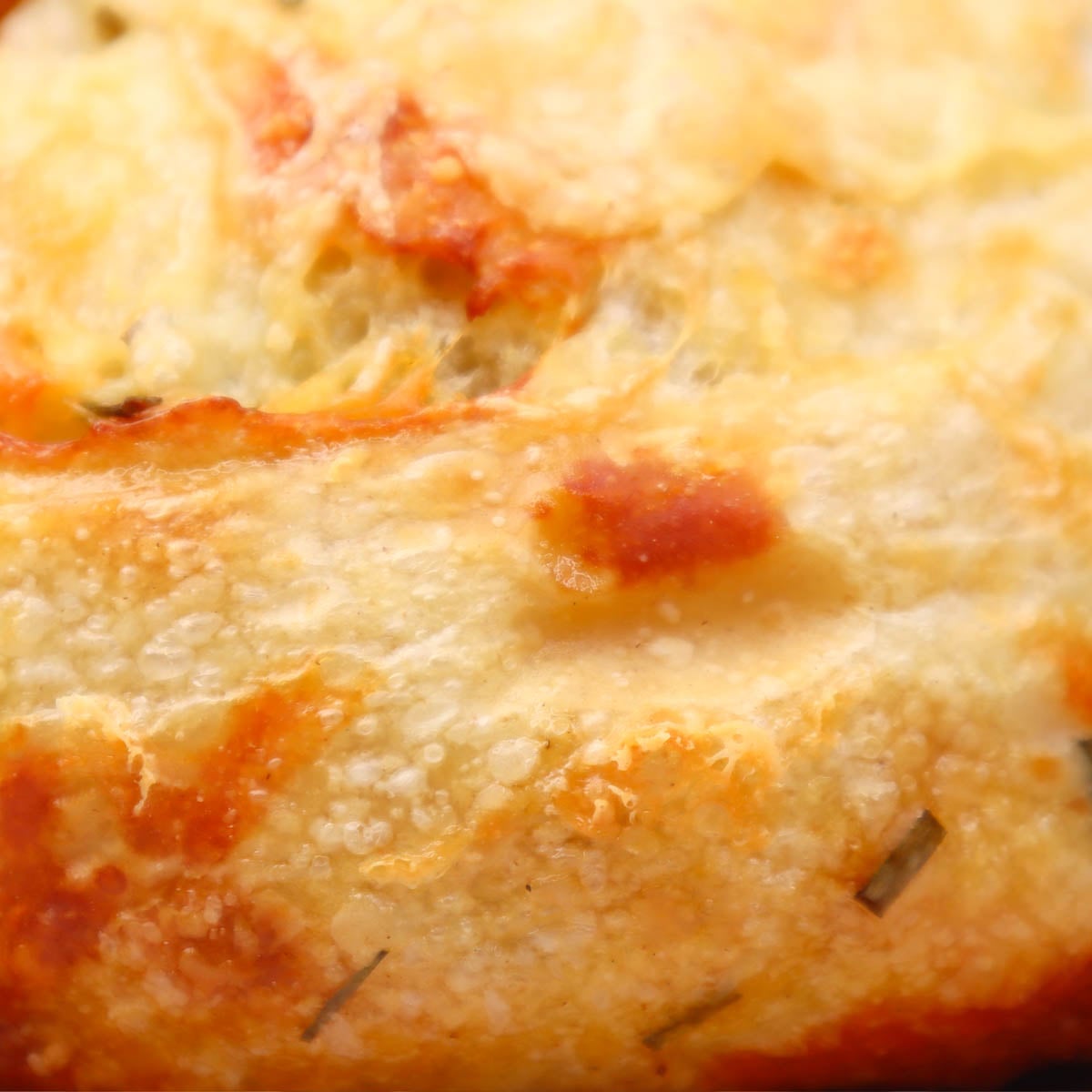 Cheese and Chive Sourdough Loaf Close-up of a rustic cheese and chive sourdough loaf with a golden crust.