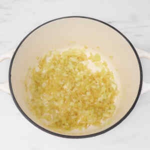 Sautéed onions in a pot, lightly browned and ready for soup preparation.