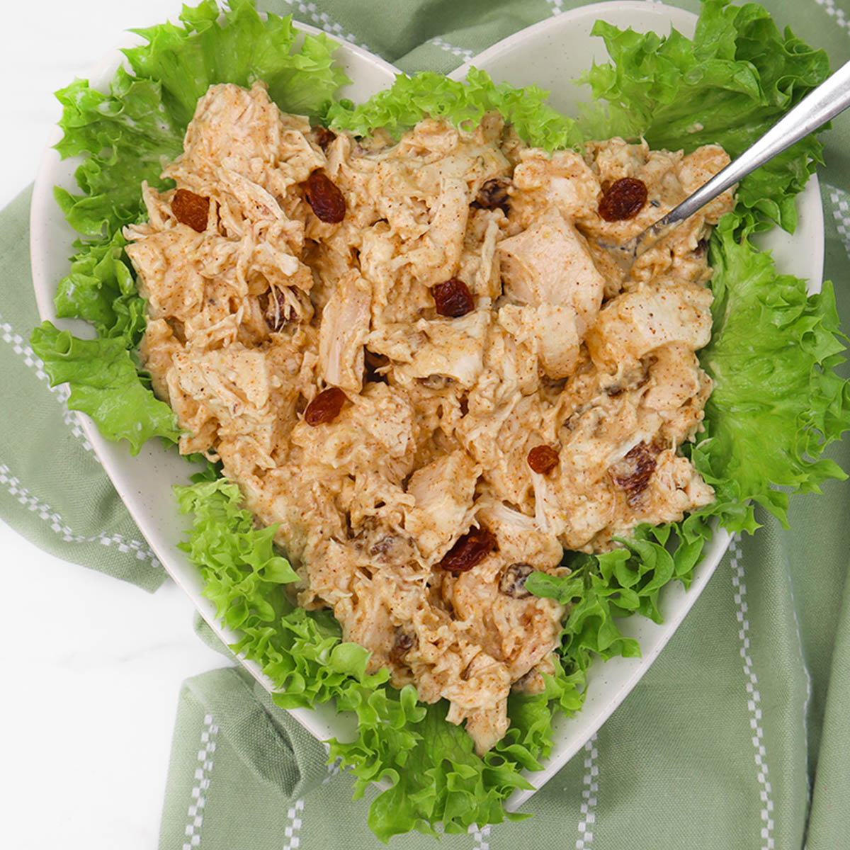 Coronation Chicken A heart-shaped dish filled with coronation chicken salad on a bed of lettuce.