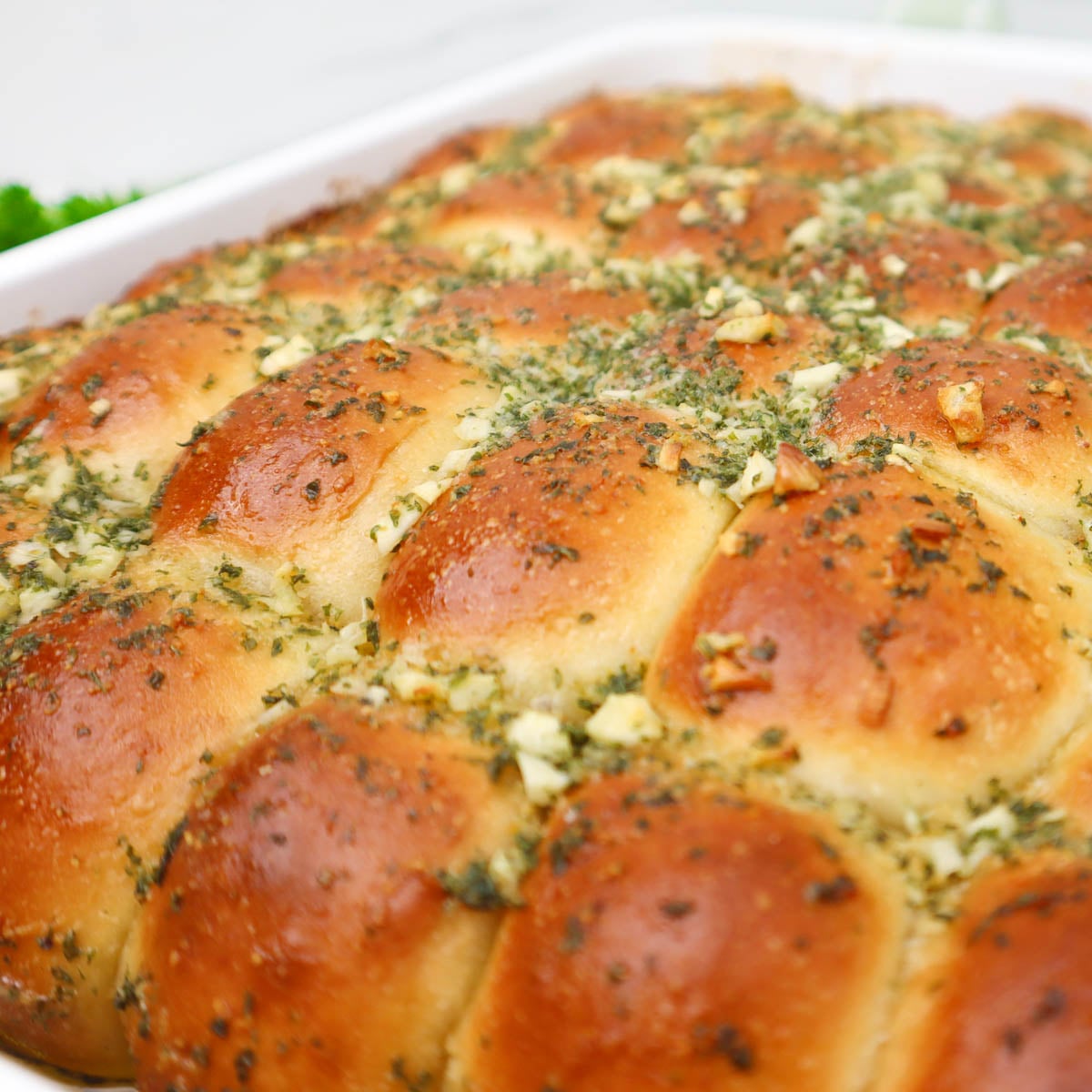 Garlic Dough Balls Golden garlic dough balls topped with herbs, arranged in a baking dish.