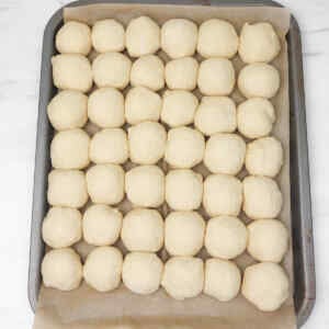 A tray filled with evenly shaped dough balls ready for baking.