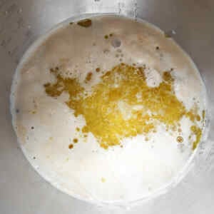 A mixture of yeast, water, and oil bubbling in a mixing bowl.