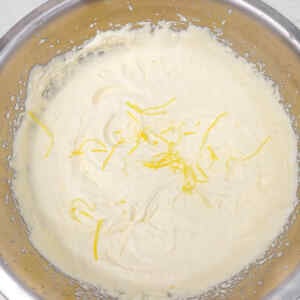 Creamy lemon ice cream mixture with lemon zest on top.