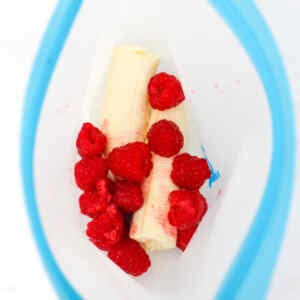 Raspberries and banana pieces in a freezer meal prep bag.
