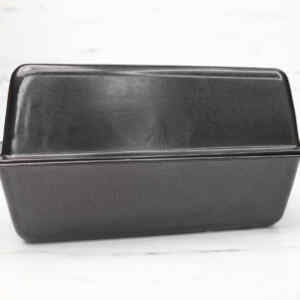 A black loaf pan used for baking sourdough sandwich bread.