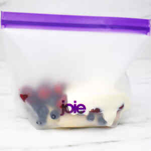 Una bolsa transparente llena de frutos rojos variados y un ingrediente cremoso, lista para preparar un batido.