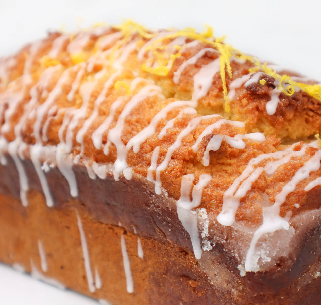 Lemon Drizzle Cake A close-up of a lemon drizzle cake topped with icing and lemon zest.