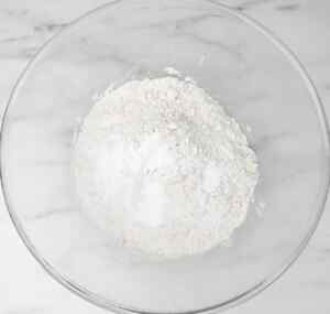 A bowl filled with a mixture of flour and baking powder.