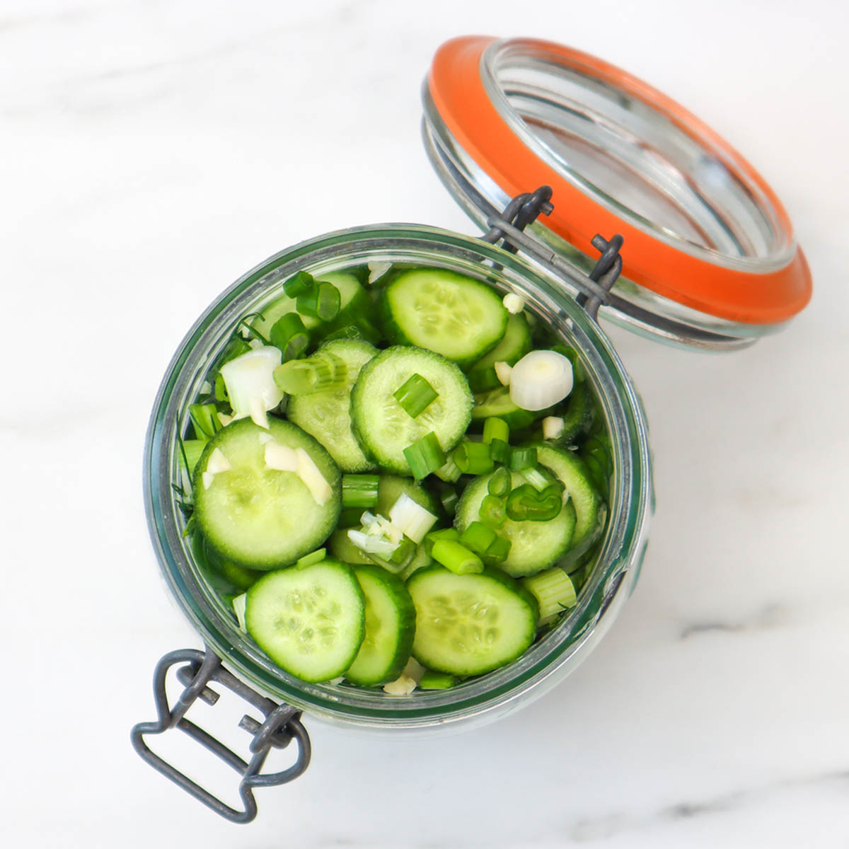 Quick Pickled Cucumbers A jar filled with sliced cucumbers and green onions, ready for quick pickling.