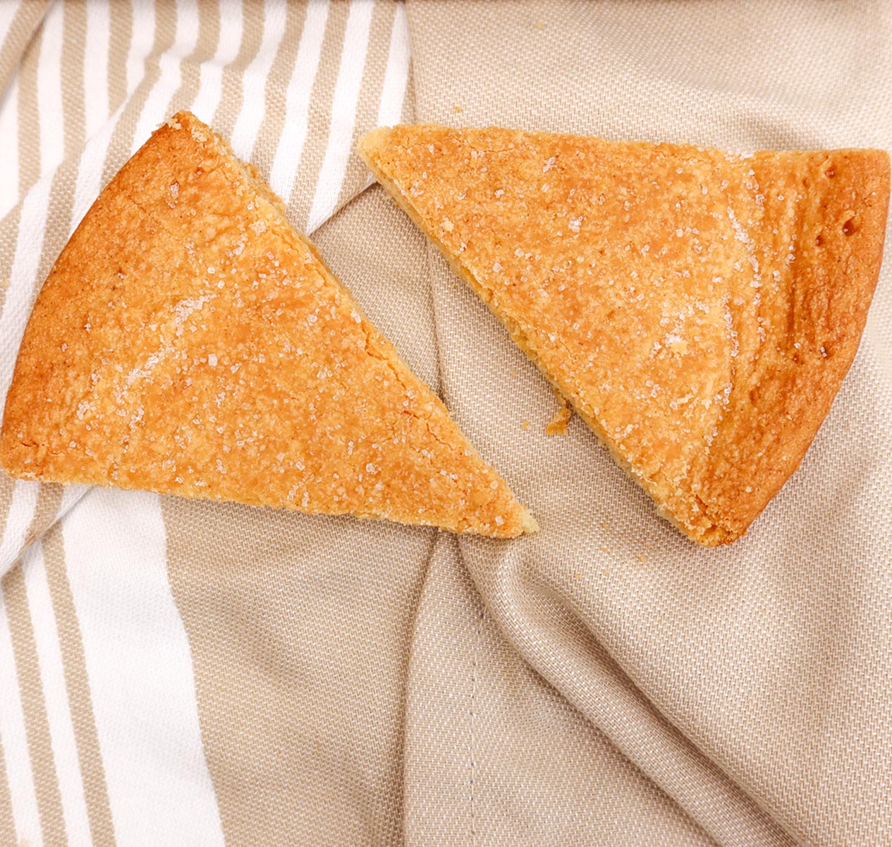 Scottish shortbread Two triangular pieces of golden Scottish shortbread on a textured cloth.