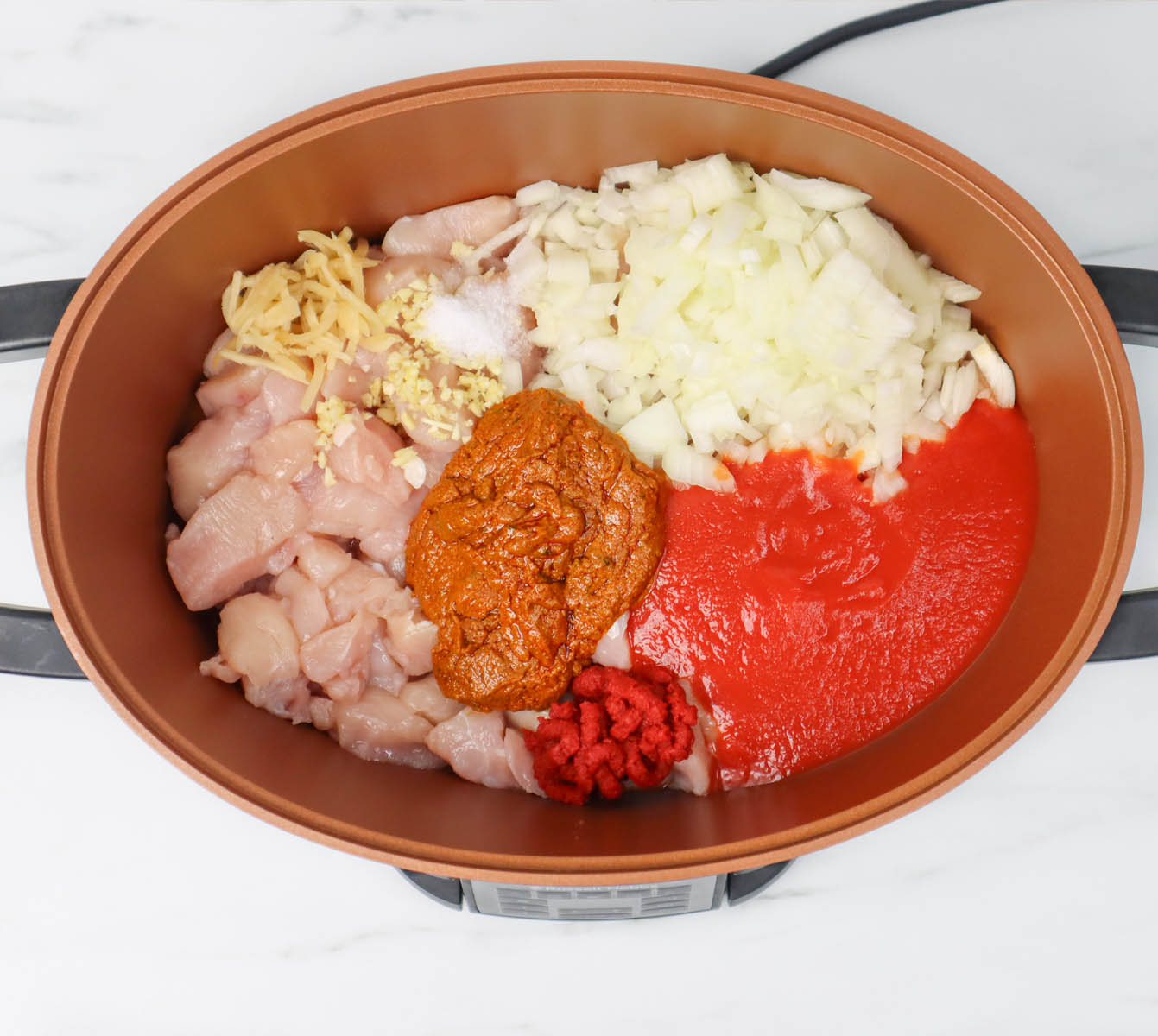 Slow Cooker Chicken Tikka Curry Ingredients for slow cooker chicken tikka curry, including chicken, onions, and sauces in a pot.