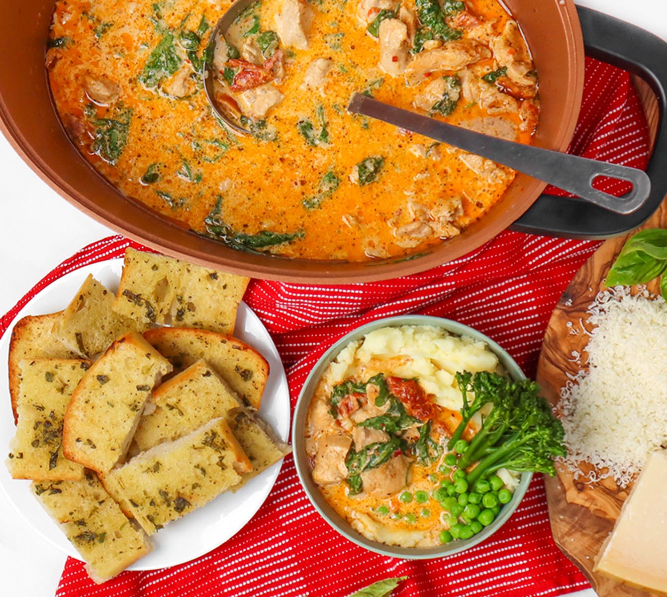 Slow Cooker Marry Me Chicken A bowl of creamy chicken with spinach and peas served over mashed potatoes, alongside garlic bread.
