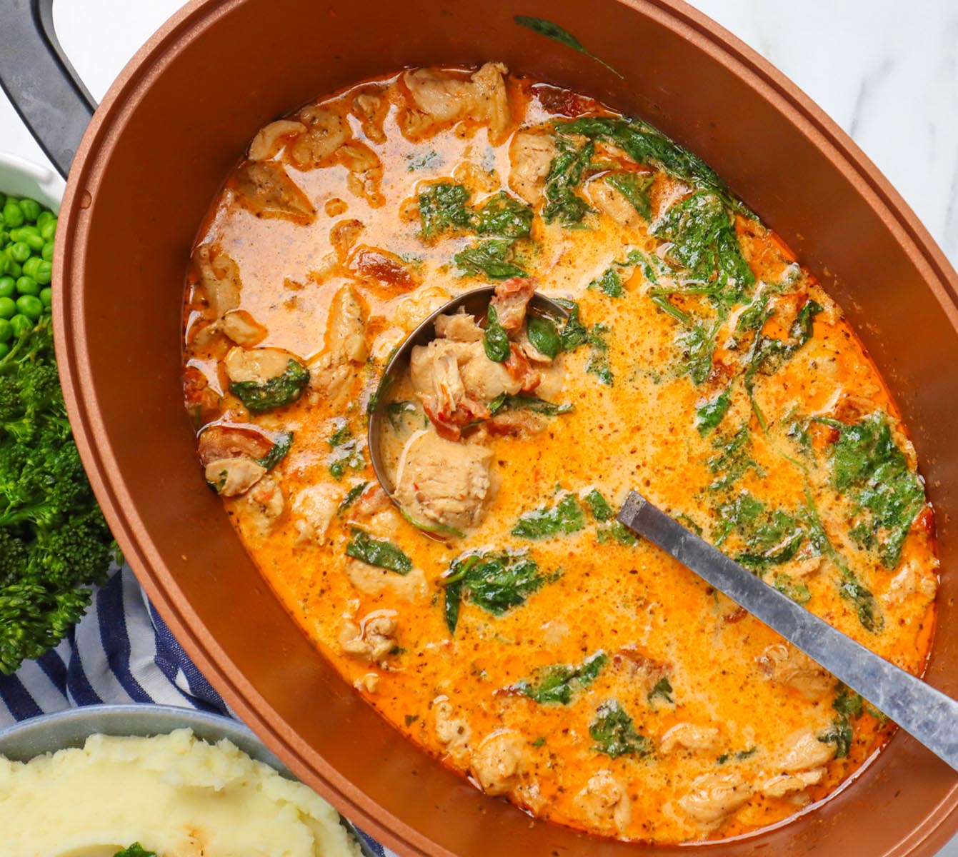 Slow Cooker Marry Me Chicken A creamy slow cooker chicken dish with spinach and herbs, served with mashed potatoes and green vegetables.