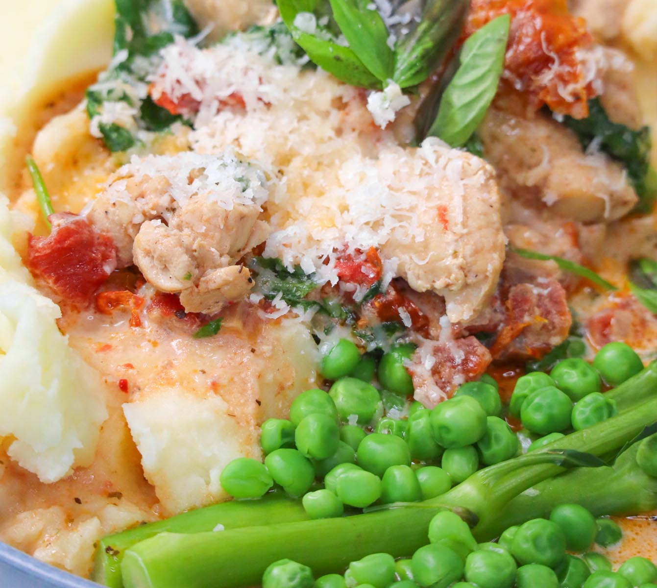 Slow Cooker Marry Me Chicken A close-up of Slow Cooker Marry Me Chicken served with mashed potatoes and green peas.