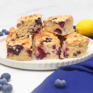 A plate of American-style blueberry biscuits with a lemon in the background.