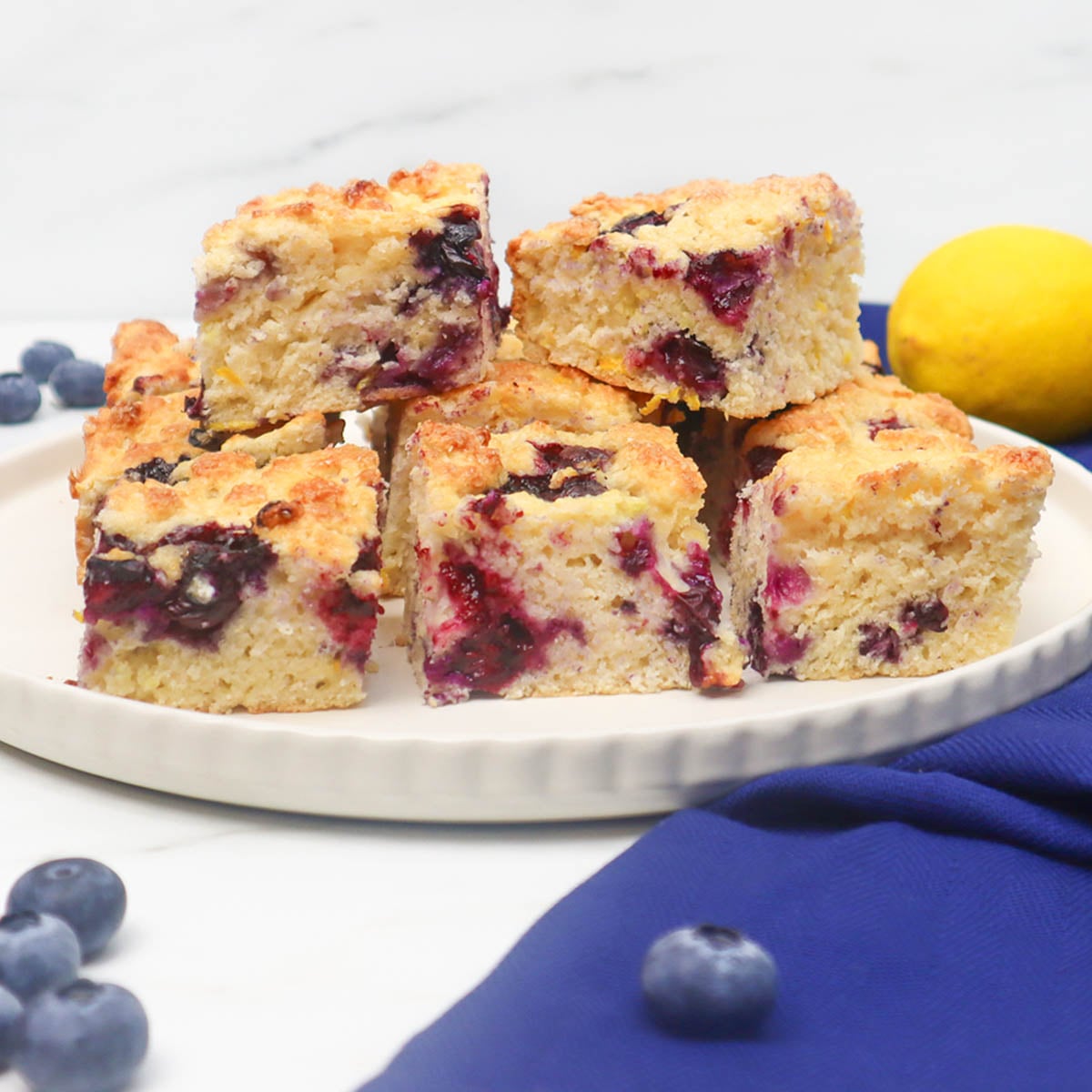A plate of American-style blueberry biscuits with a lemon in the background.