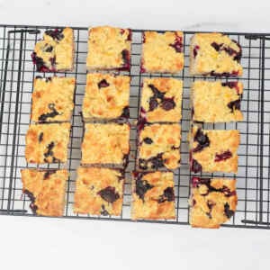 Freshly baked blueberry biscuits cooling on a wire rack.